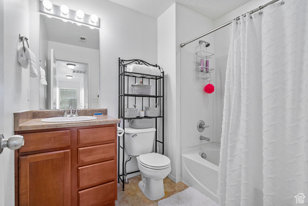 Full bath featuring visible vents, shower / bath combo, vanity, and toilet