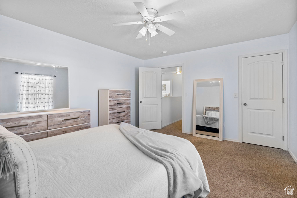 Carpeted bedroom featuring a ceiling fan and baseboards