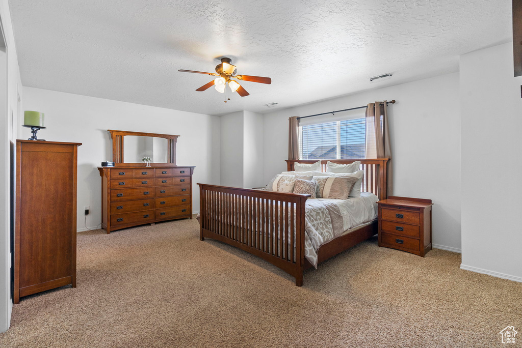 Bedroom with carpet floors, a ceiling fan, visible vents, and baseboards