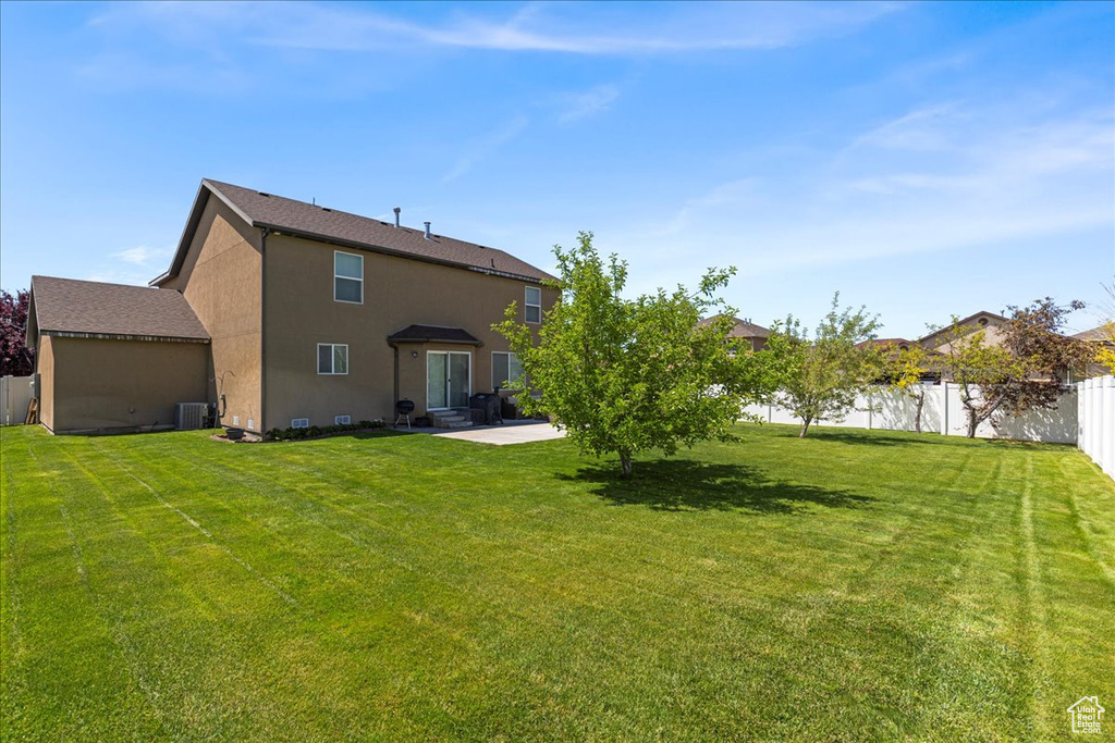 Rear view of house with a patio, central air condition unit, and stucco siding