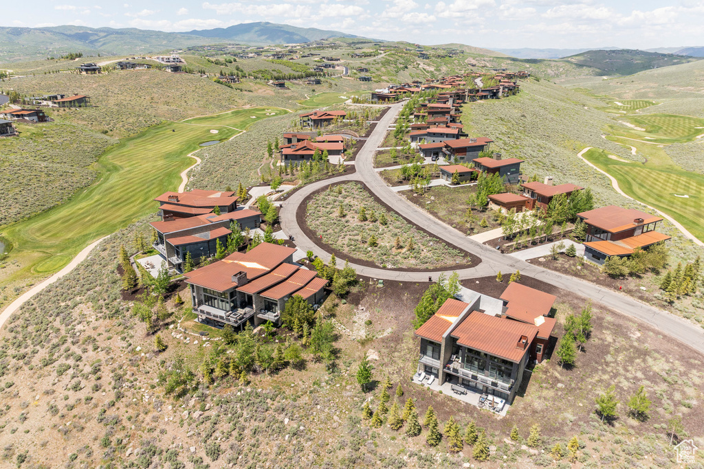 Drone / aerial view of a mountain backdrop and a local golf course