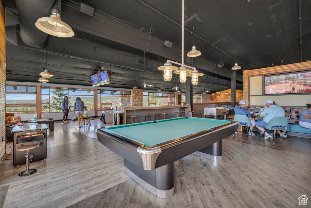Rec room featuring billiards table, wood finished floors, and a community bar