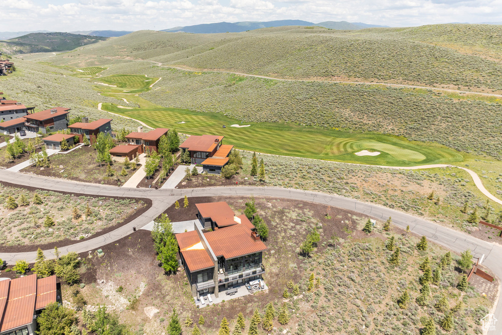 View of property location featuring a mountainous background and a local golf course