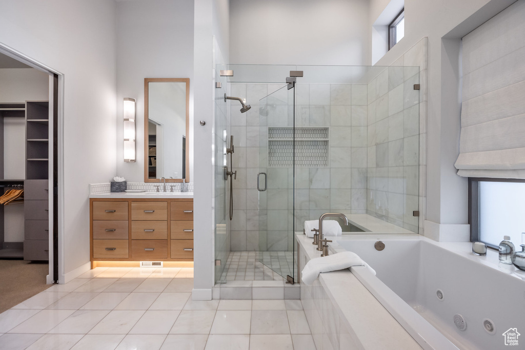 Full bathroom with vanity, a shower stall, a jetted tub, and tile patterned flooring