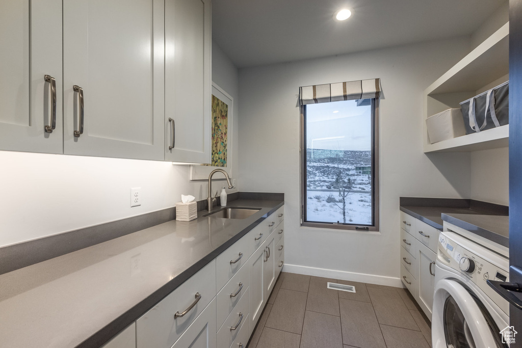 Laundry room featuring washer / dryer, cabinet space, dark tile patterned flooring, and recessed lighting