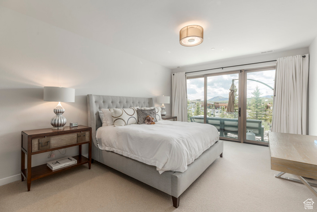Bedroom with light carpet and access to outside