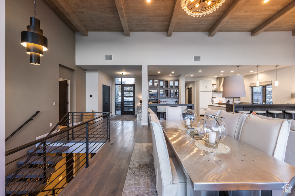 Dining room with dark wood-type flooring and a wooden ceiling with exposed beams