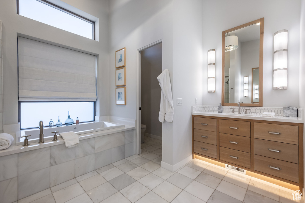Full bathroom featuring vanity, a garden tub, and tile patterned floors