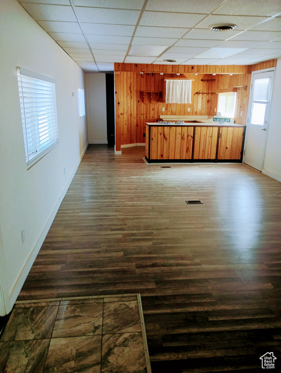 Kitchen featuring visible vents, dark wood finished floors, wooden walls, and a drop ceiling