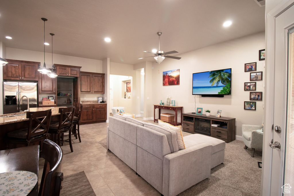 Living area with ceiling fan, recessed lighting, and light tile patterned flooring