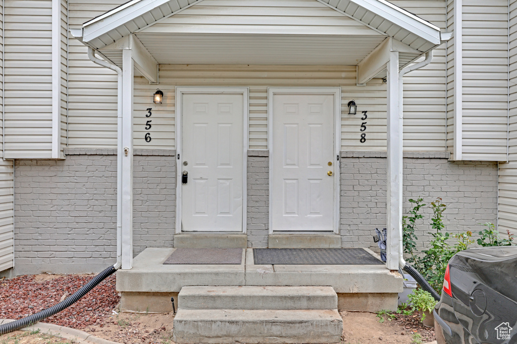 Doorway to property featuring brick siding