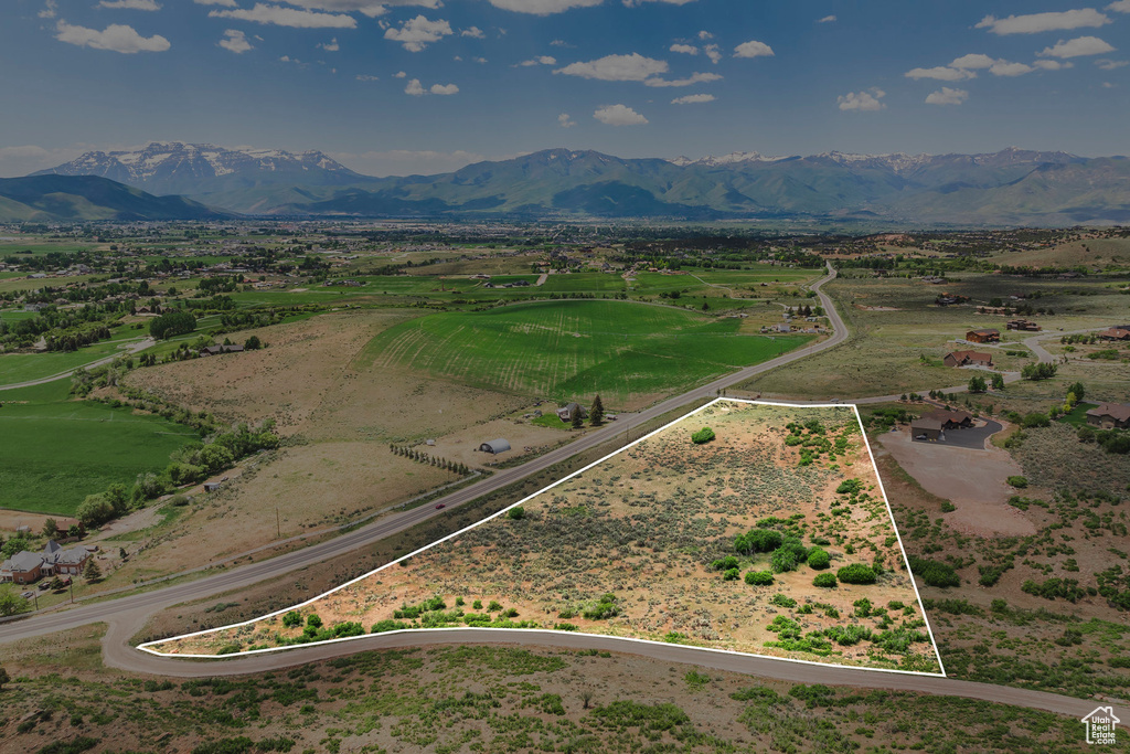 Aerial view of sparsely populated area featuring property boundaries highlighted and a mountain backdrop