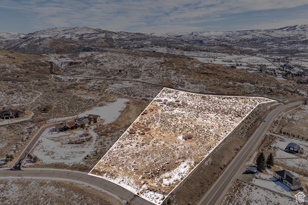 Aerial view of property and surrounding area with a mountain backdrop