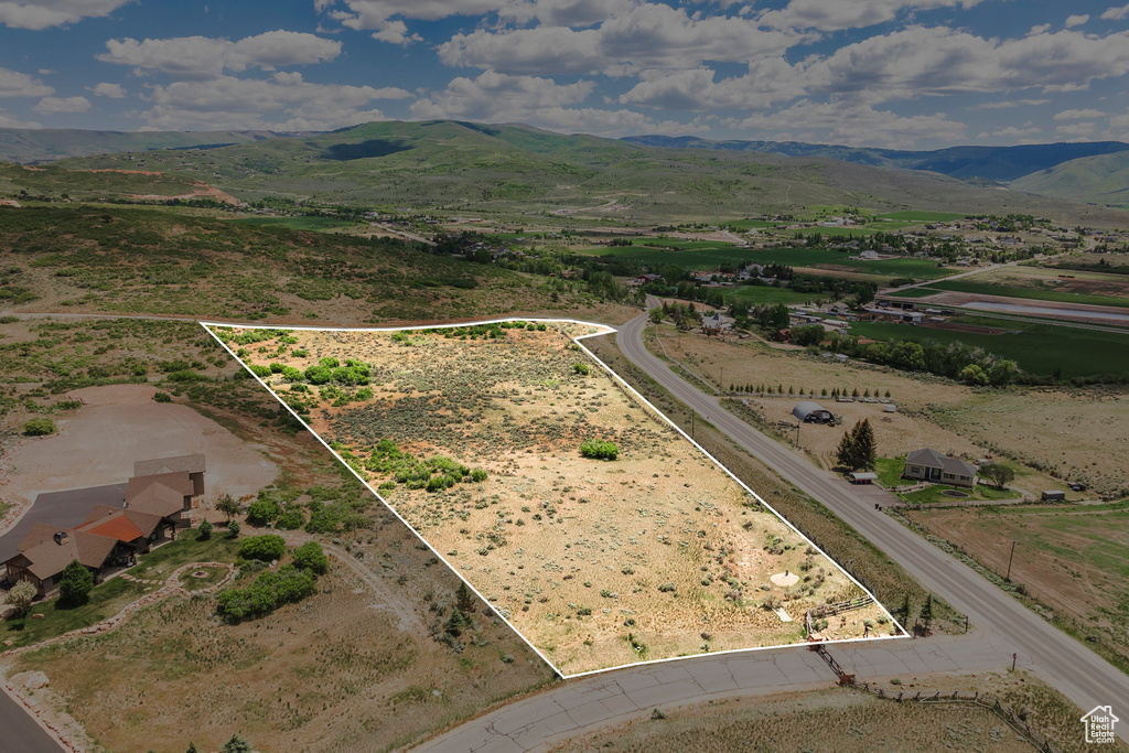 Overview of rural landscape with property parcel outlined and a mountainous background
