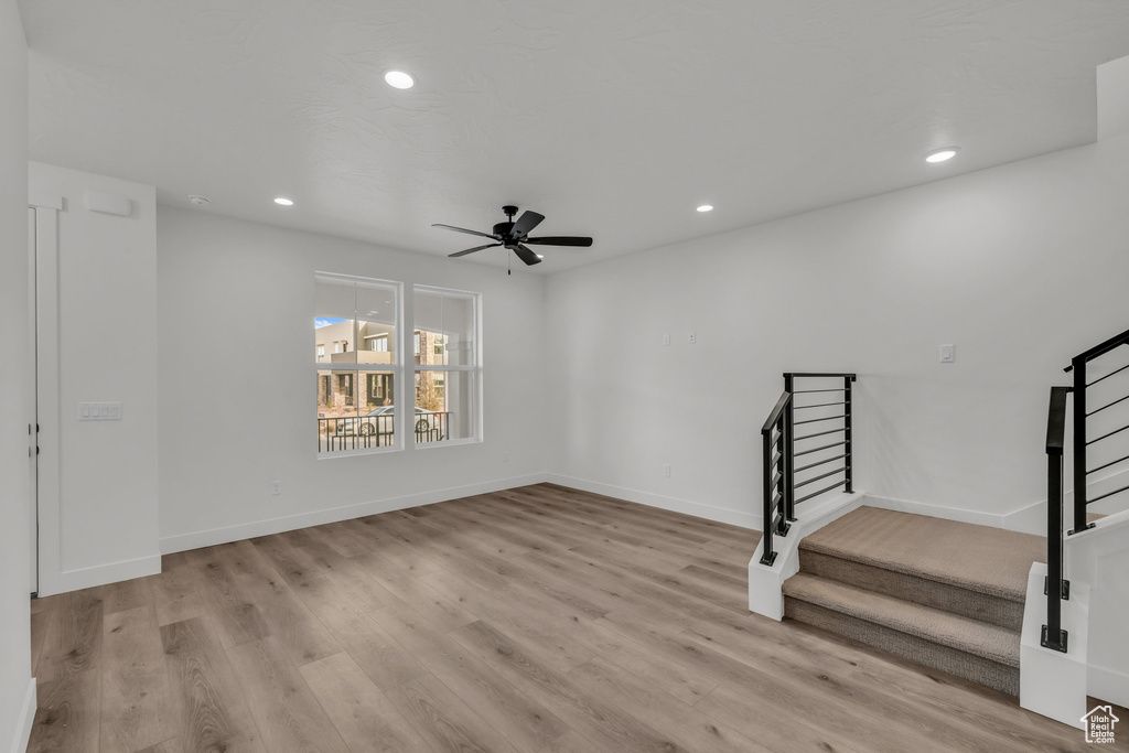 Unfurnished room with light wood finished floors, recessed lighting, a ceiling fan, baseboards, and stairs
