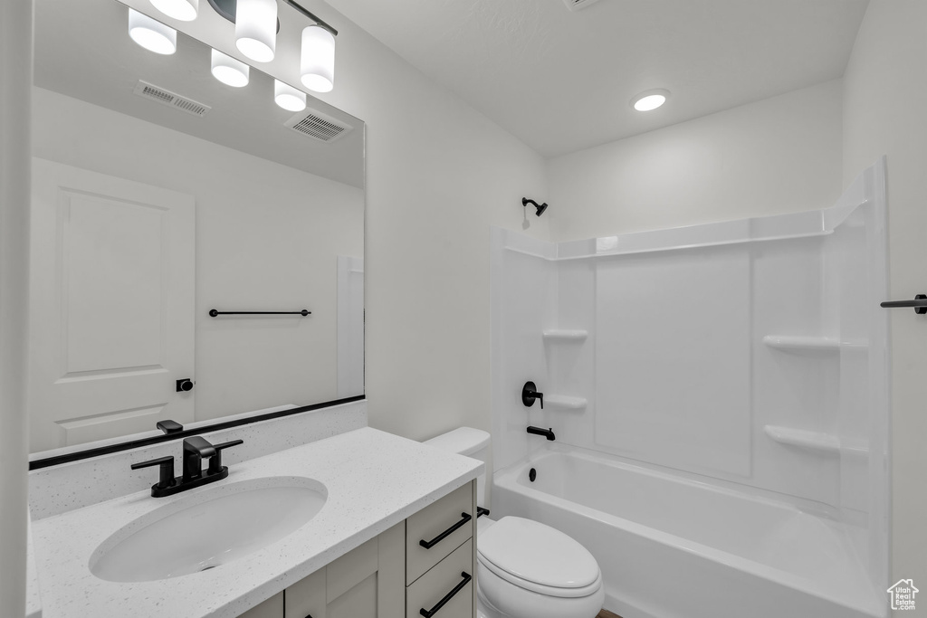 Full bath with toilet, visible vents,  shower combination, and vanity