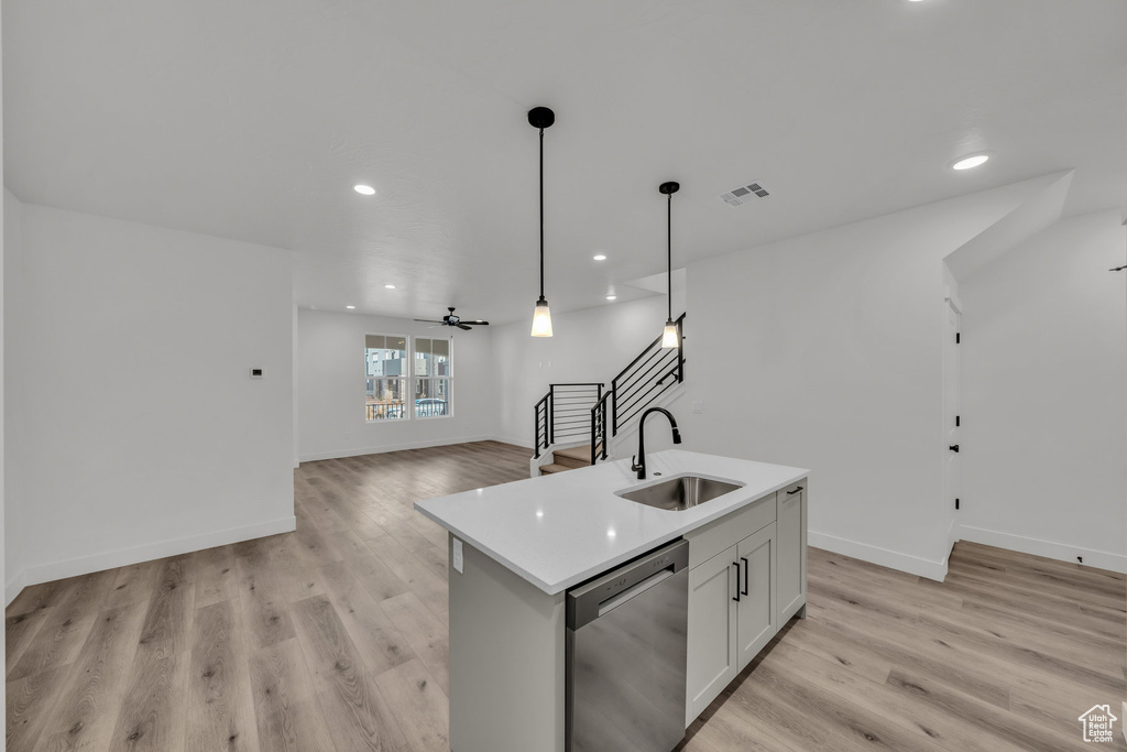 Kitchen with a sink, visible vents, light wood-style floors, open floor plan, and stainless steel dishwasher