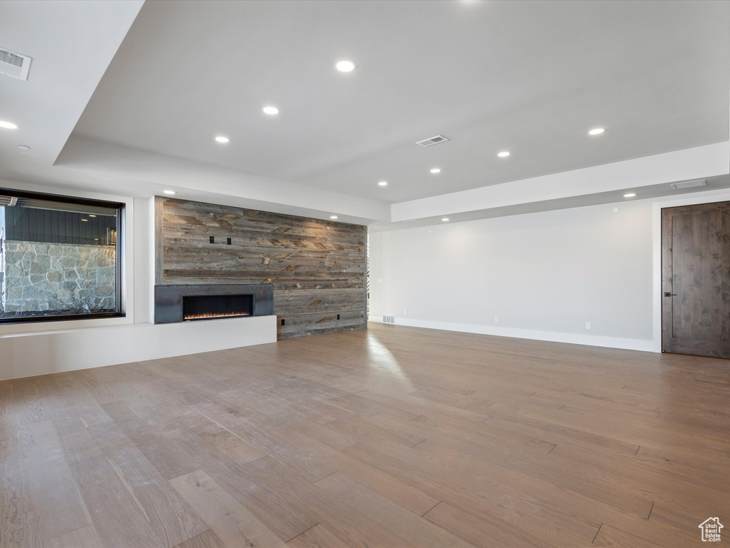 Unfurnished living room with recessed lighting, visible vents, a fireplace, and wood finished floors