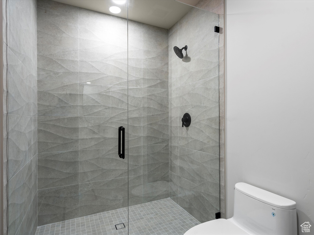 Bathroom with a shower stall and toilet