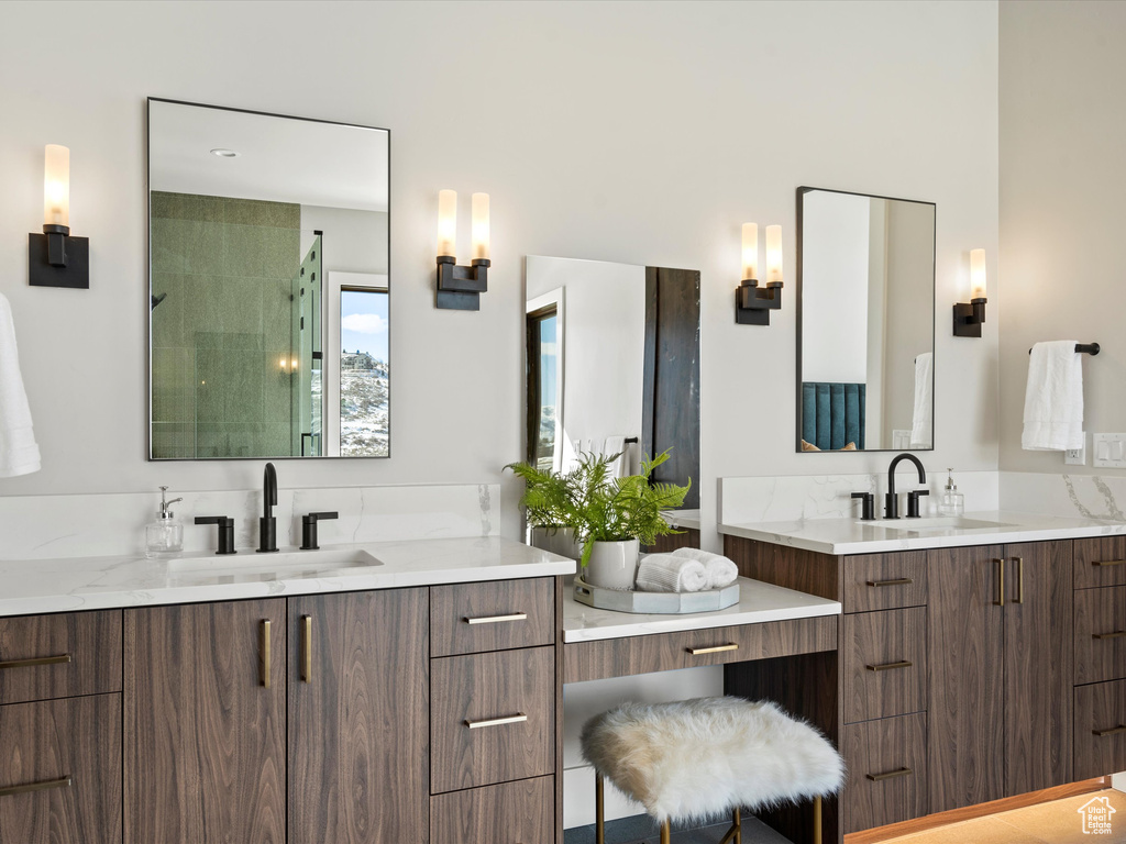 Bathroom with two vanities, tiled shower, and a sink