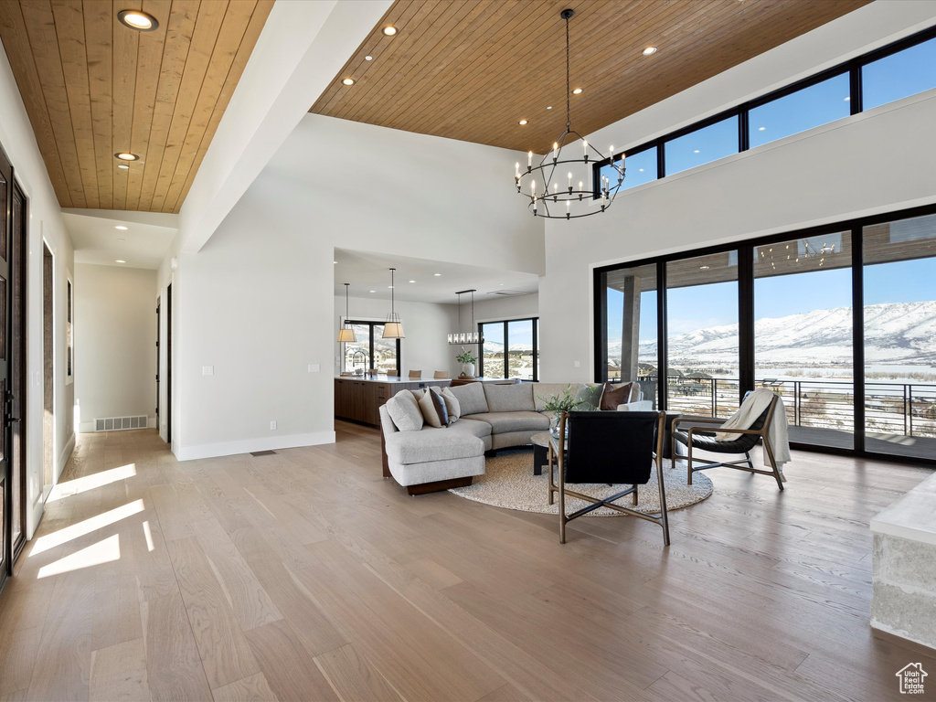 Living room with baseboards, wooden ceiling, light wood-style floors, a chandelier, and a mountain view