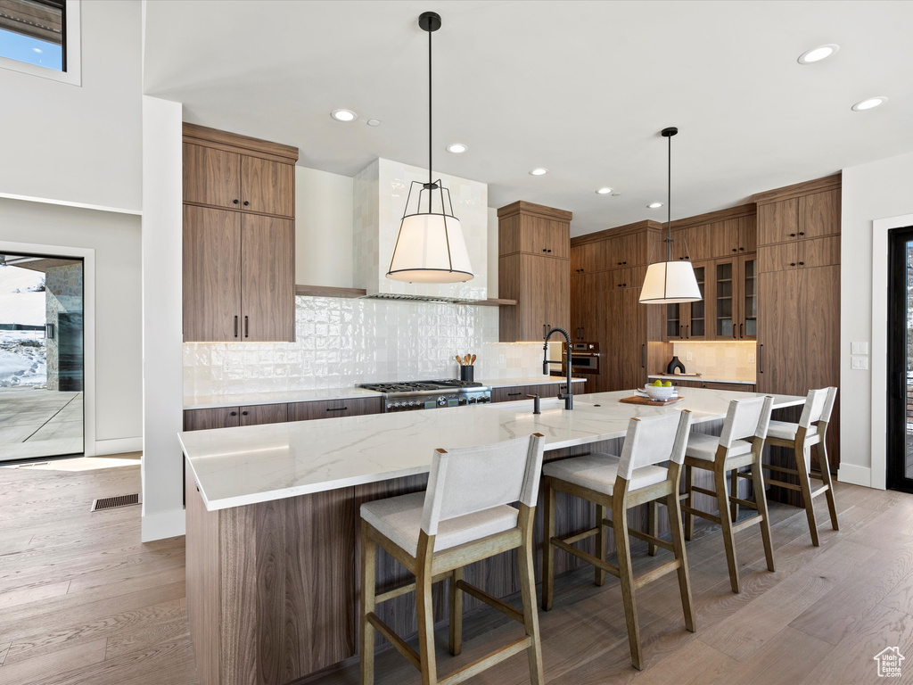 Kitchen with stainless steel gas cooktop, a large island, modern cabinets, and visible vents