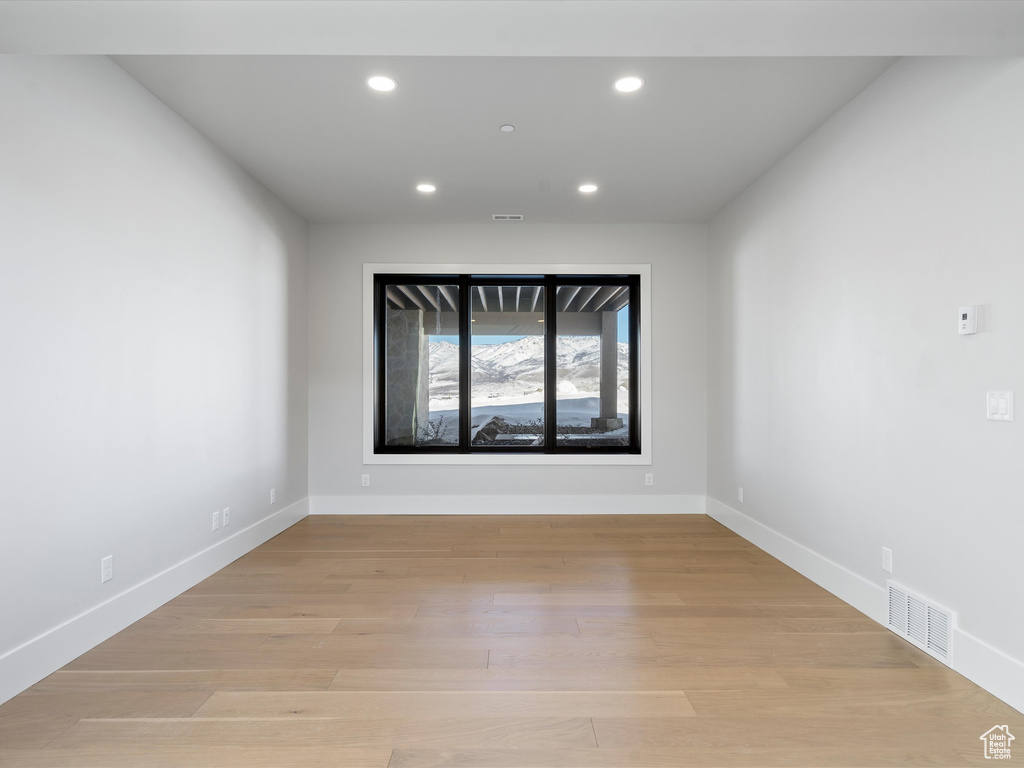 Spare room featuring light wood-style floors, baseboards, visible vents, and recessed lighting