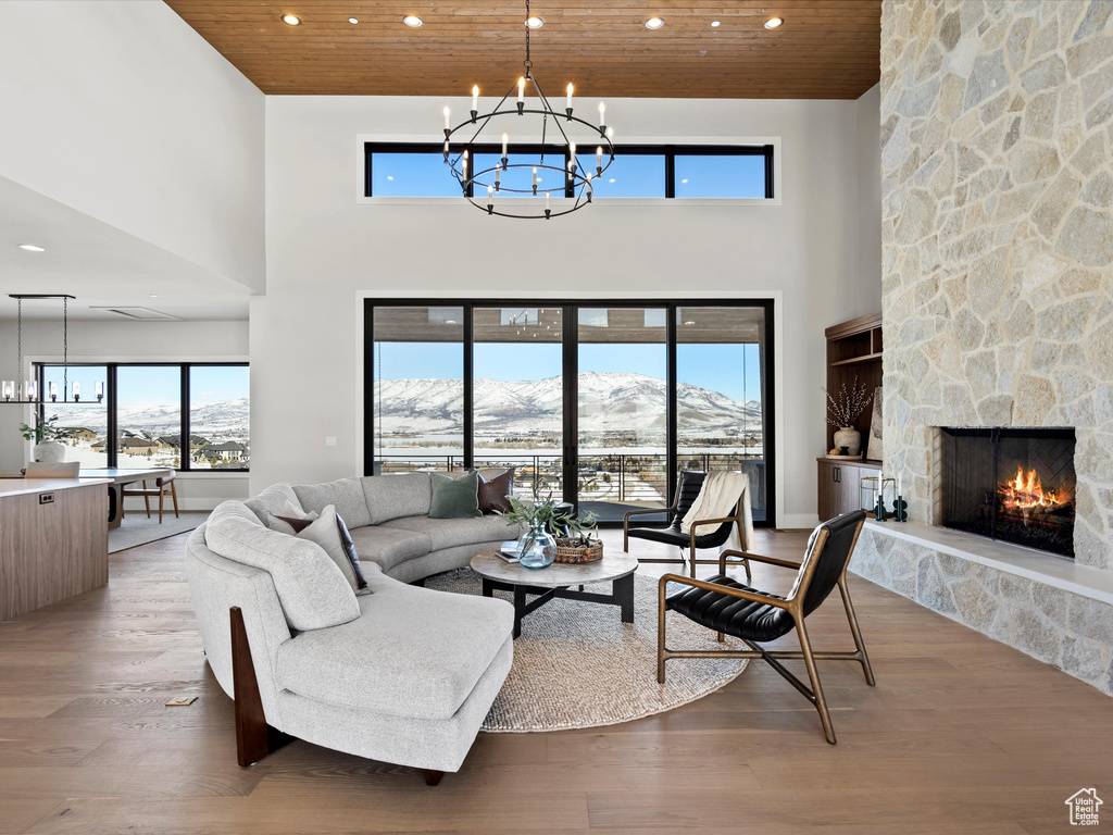 Living area with wooden ceiling, a fireplace, a notable chandelier, and wood finished floors