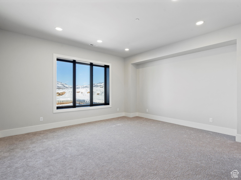 Carpeted spare room with baseboards, visible vents, and recessed lighting