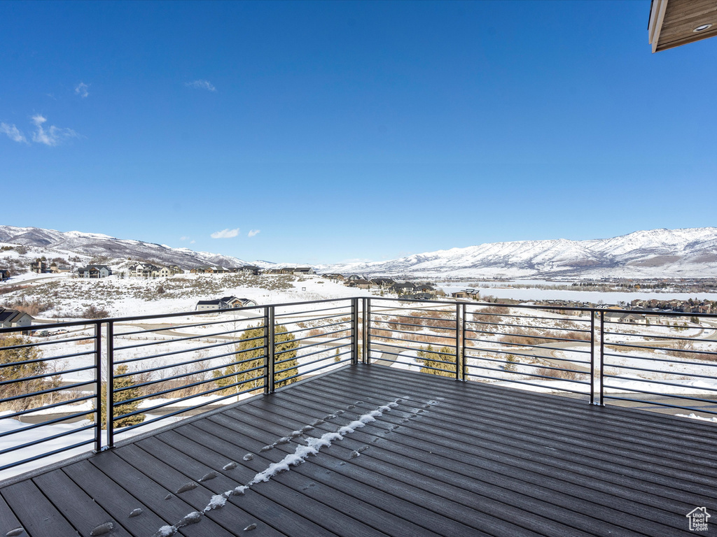 Snow covered deck featuring a mountain view