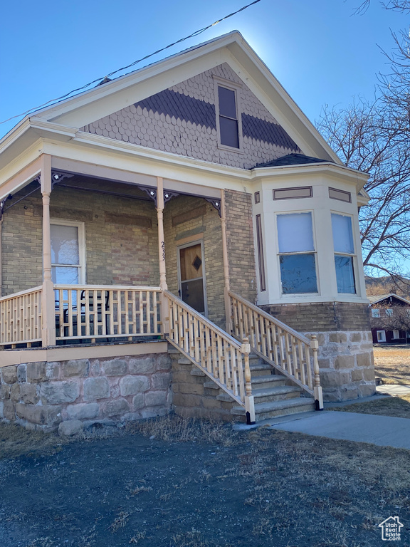 View of front facade with covered porch and brick siding