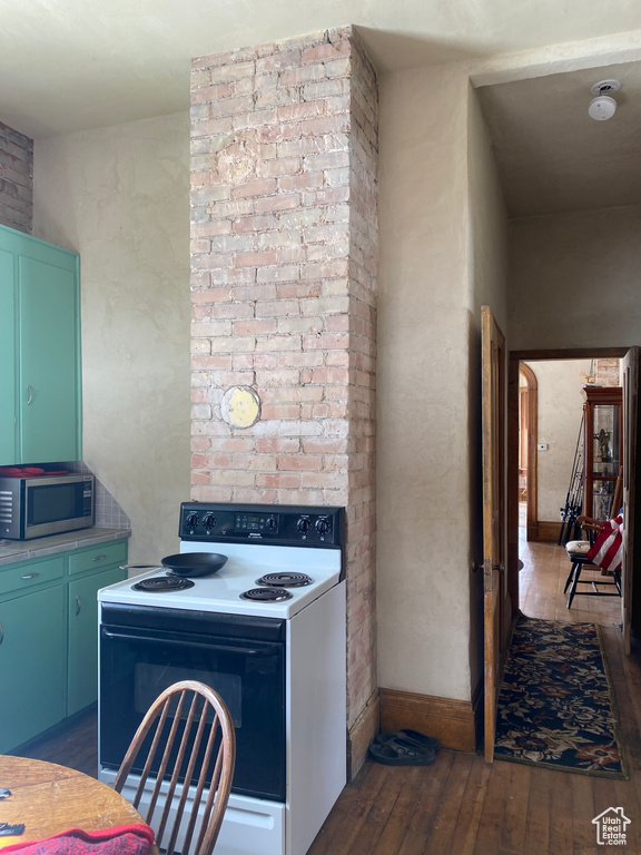 Kitchen with arched walkways, baseboards, electric stove, hardwood / wood-style floors, and stainless steel microwave