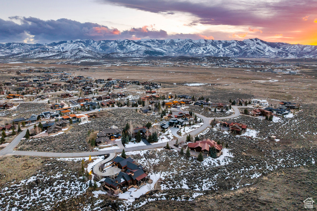 Snowy aerial view featuring a mountain view and a residential view
