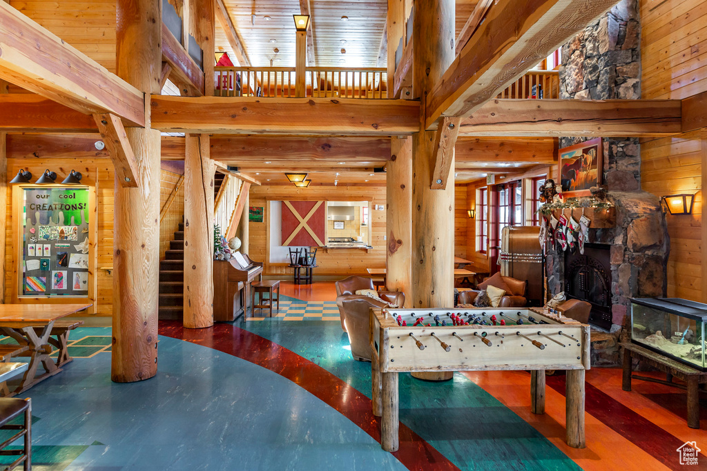 Rec room with wooden walls and a towering ceiling