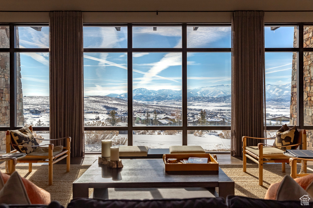 Living area featuring a mountain view, healthy amount of natural light, and a wall of windows