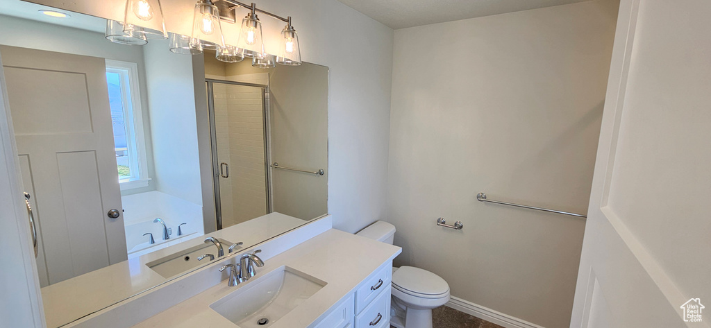 Full bathroom with vanity, baseboards, a shower stall, and toilet