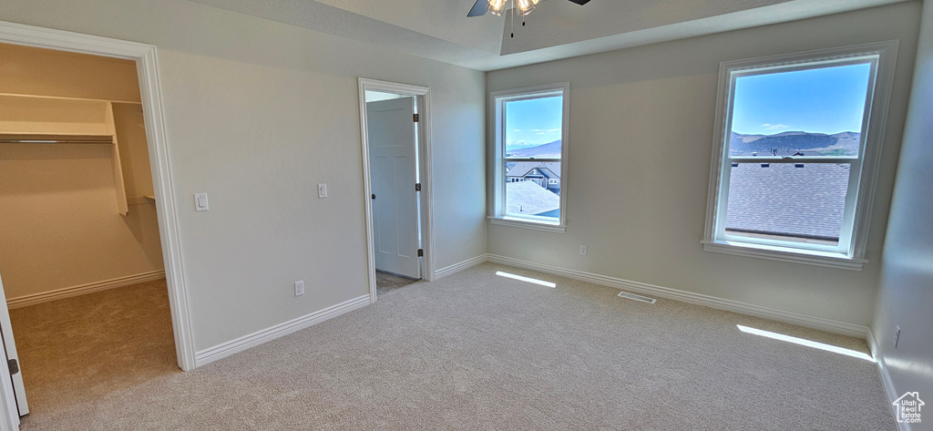 Unfurnished bedroom with a closet, visible vents, baseboards, light colored carpet, and a spacious closet