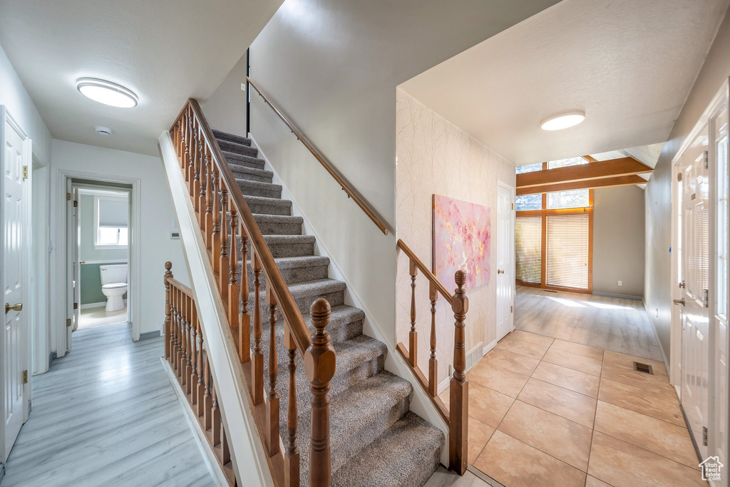 Staircase featuring visible vents, tile patterned floors, and baseboards