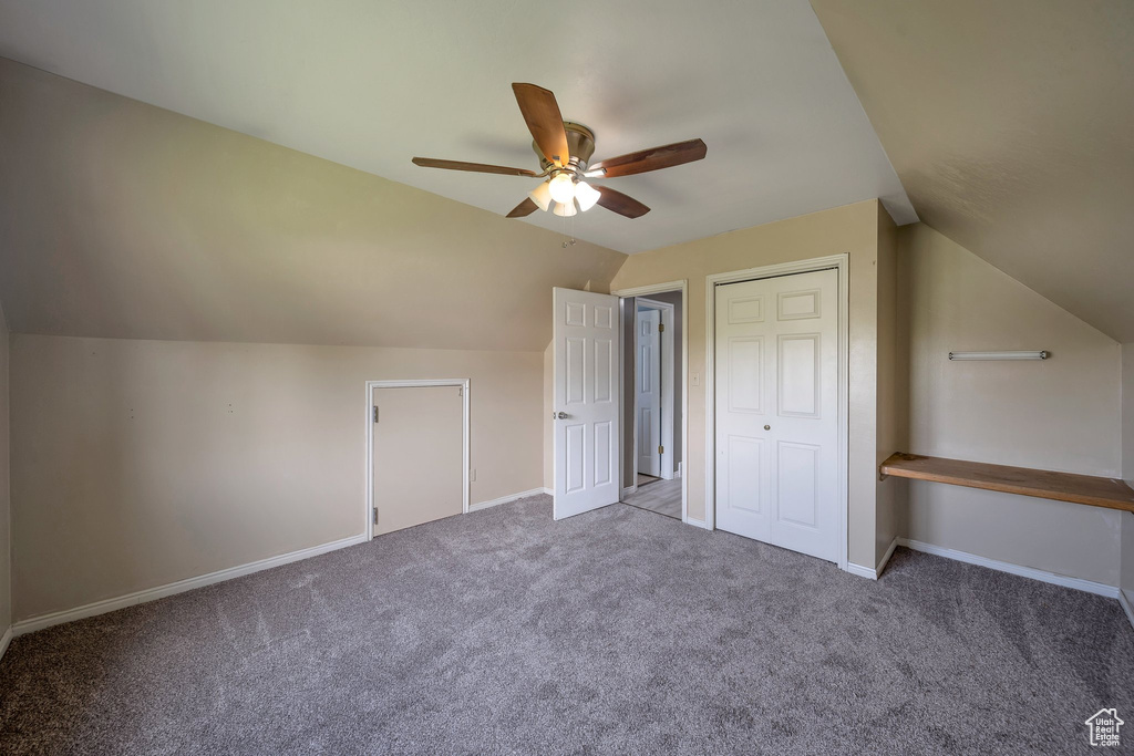 Additional living space featuring a ceiling fan, carpet flooring, vaulted ceiling, and baseboards