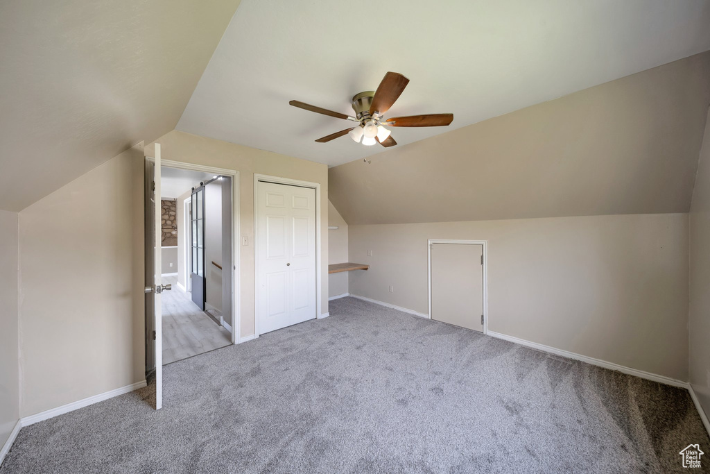 Additional living space with a ceiling fan, lofted ceiling, carpet, and baseboards