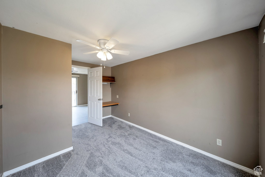 Spare room with ceiling fan, baseboards, and carpet floors