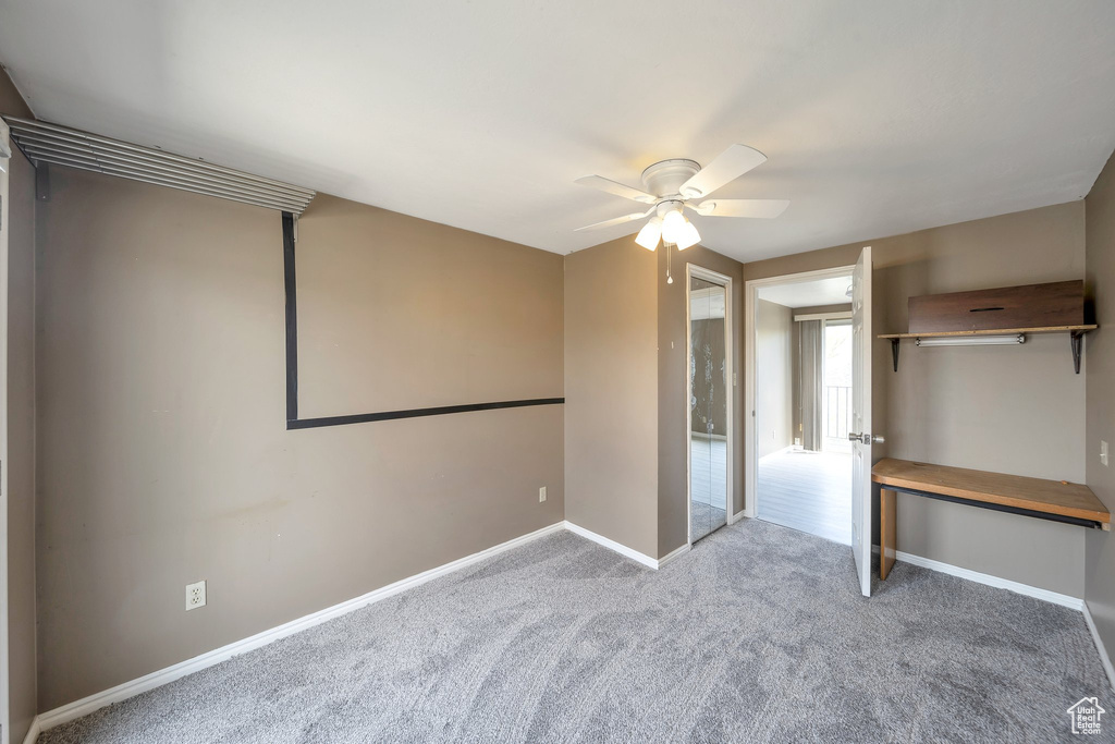 Unfurnished bedroom with carpet, a ceiling fan, and baseboards