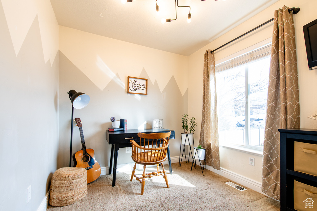 Carpeted home office with visible vents and baseboards
