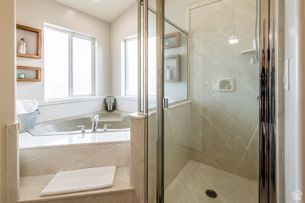 Bathroom with a marble finish shower and a bath
