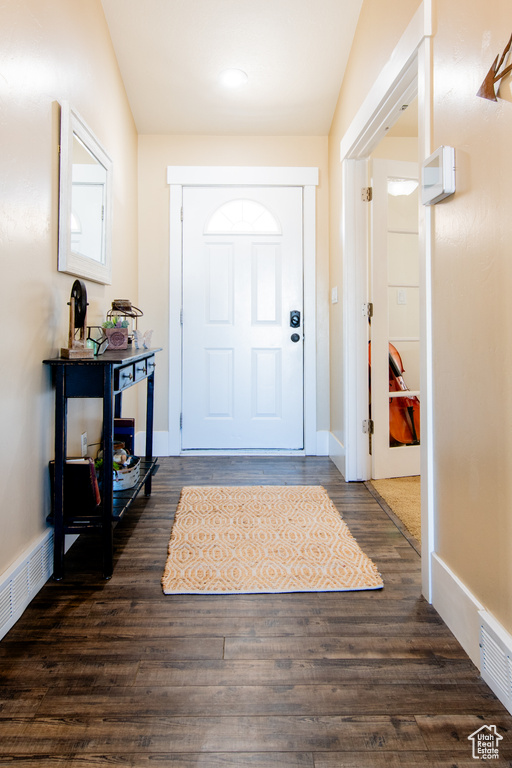 Entryway with dark wood-type flooring and baseboards