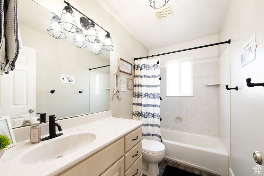 Bathroom with visible vents, shower / tub combo with curtain, vanity, and toilet