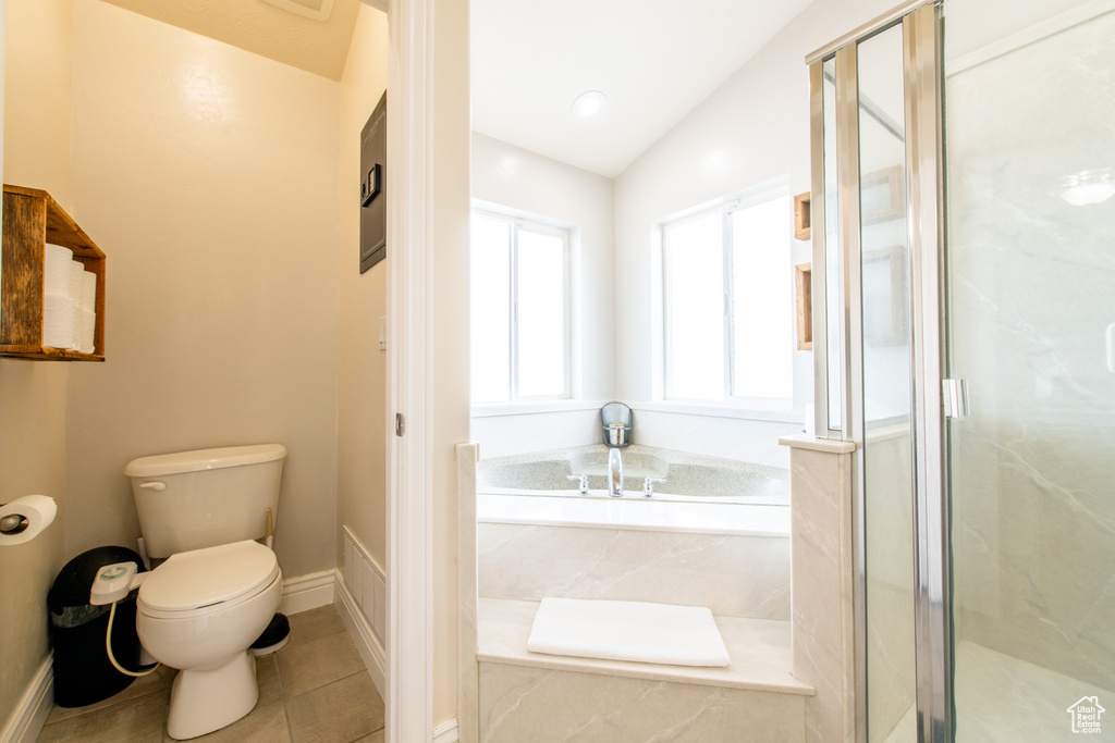 Bathroom featuring tile patterned flooring, toilet, vaulted ceiling, a marble finish shower, and a bath