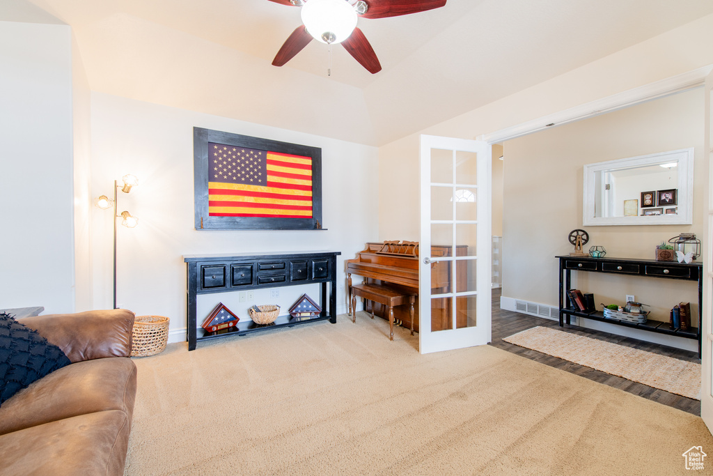 Carpeted living area featuring ceiling fan, french doors, visible vents, and baseboards
