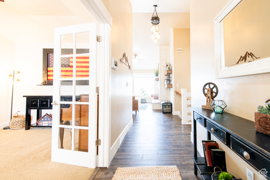 Corridor with a chandelier, french doors, baseboards, and wood finished floors