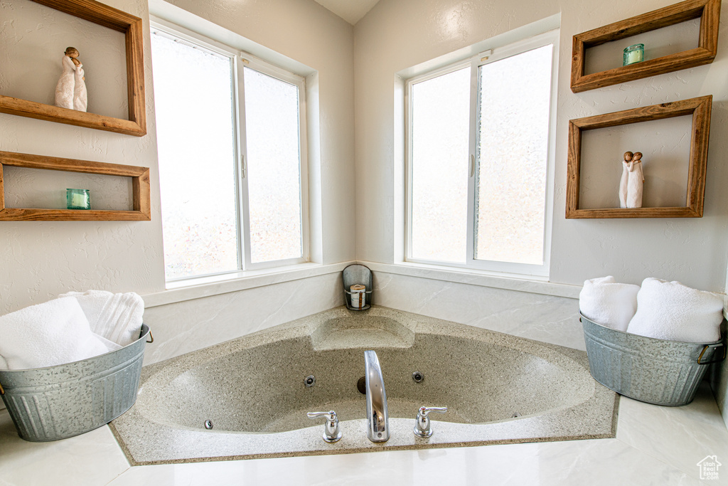 Full bath featuring plenty of natural light and a whirlpool tub